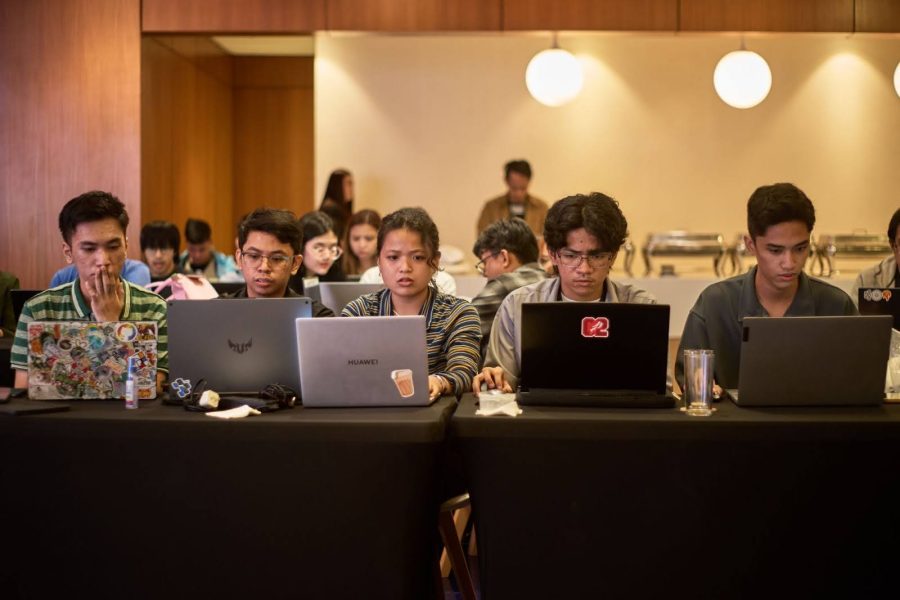 Globe Vertex AI Hands-on Labs Champion Melissa Mae Miranda (middle) from the Pamantasan ng Lungsod ng Maynila hard at work on her Gen AI application, seated with her schoolmates.